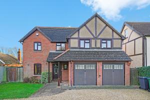 a red brick house with two garage doors at Detached 6 Bedroom Cambridgeshire Abode - Pets in Whittlesford