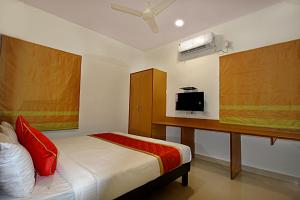 a bedroom with a bed and a desk with a tv at Airport Bliss Boutique Hotel in Yelahanka