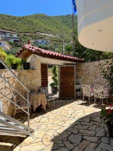 a house with a patio with a table and chairs at Vila Memaj in Vlorë