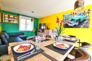 a dining room with a table and a green wall at Villa Cuba - Domaine Le Sherwood in Notre-Dame-de-Monts