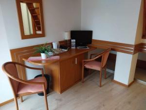 a room with a desk with a computer and two chairs at Erhardt Panzió in Sopron