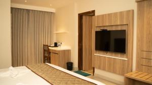 una camera d'albergo con un letto e una TV a schermo piatto di Hotel Devdeep Porvorim ad Alto Porvorim