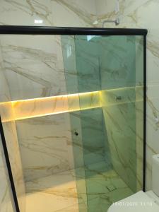 a glass shower in a bathroom with a marble wall at Apto Lindo e Aconchegante 3 in Manaus +15 photos