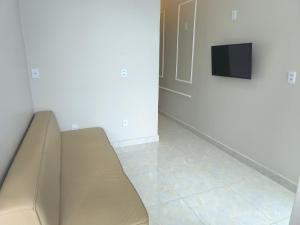a couch sitting in a room with a tv at Apto Lindo e Aconchegante 3 in Manaus