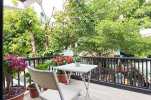 a table and chairs on a balcony with plants at Baan Ploen Dee - Wat Arun in Bangkok