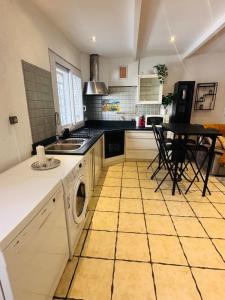 レ・ペンヌ・ミラボーにあるTriplex cosy au cœur du villageのタイルフロアのキッチン(洗濯機、乾燥機付)