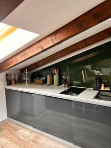 a kitchen with gray cabinets and a counter top at Cozy Alpine Attic in Savièse +18 photos