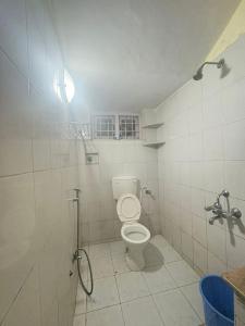 a white bathroom with a toilet and a shower at 11 Haven Street Kodaikanal in Kodaikānāl