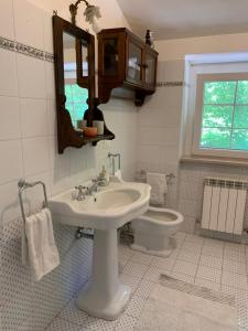 une salle de bain avec un lavabo, des toilettes et un miroir dans l'établissement Vrijstaand vakantiehuis La Piccigliana - 6 personen, à Montelaterone 30 autres photos