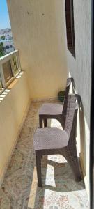 two chairs and a table on a balcony at Appartement des familles in Fnidek