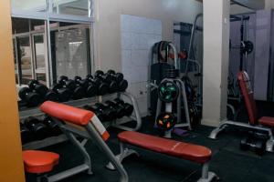 a gym with dumbbells and weights in a room at Esiram Hotel in Narok