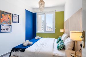 1 dormitorio con 1 cama grande y paredes azules y verdes en Whispering Palms 1-BR Apt By Finikoudes Beach, en Lárnaca