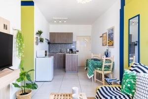Una cocina y una sala de estar con una mesa. en Whispering Palms 1-BR Apt By Finikoudes Beach, en Lárnaca