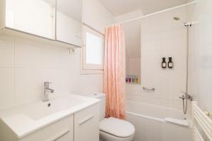 a white bathroom with a sink and a toilet at ARTSY Apartment 3BTH and 6BR FIRA Montjuic Plaza España FCB in Barcelona