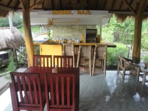 a restaurant with a table and chairs and a bar at We'Be Cottages in Gili Meno