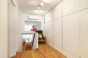 a hallway with white cabinets and a table in a room at ARTSY Apartment 3BTH and 6BR FIRA Montjuic Plaza España FCB in Barcelona