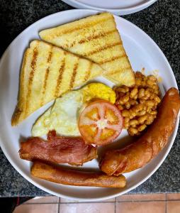 a plate of breakfast food with eggs bacon beans and toast at Gold Crown International Hotel With Complementary Breakfast and WiFi in Johannesburg
