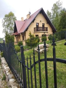 Ein schwarzer Zaun vor einem Haus in der Unterkunft Mikołajówka - przytulny dom z widokiem in Świeradów-Zdrój
