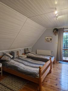 1 Schlafzimmer mit 2 Betten im Dachgeschoss in der Unterkunft Mikołajówka - przytulny dom z widokiem in Świeradów-Zdrój