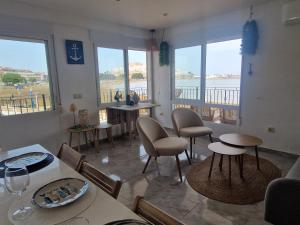 a living room with tables and chairs and windows at Villa Brisamar - On the beach in Peniscola