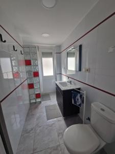 a bathroom with a white toilet and a sink at Villa Brisamar - On the beach in Peniscola +4 photos