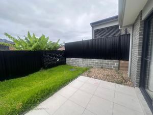 a backyard with a fence and green grass at Spacious Queen Room with Attached Bathroom - OR1 in Guildford