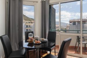 Un comedor con mesa y sillas y una ventana. en Golden Star AU by An Island Apart, en Funchal