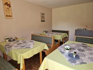 a restaurant with two tables with green and white table cloth at Gästehaus Rehm in Prinzbach