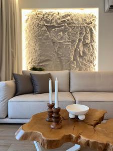 ein Wohnzimmer mit einer Couch und einem Tisch mit Kerzen in der Unterkunft Luxury apartment 70m2 with 2 bedrooms ,balcony and jacuzzi , Downtown Thessaloniki in Thessaloniki