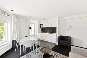 a kitchen and living room with a table and chairs at B's Strandappartementen in Domburg