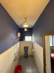 a bathroom with a toilet in a blue wall at HostelExp, Varkala - A Beach Town Hostel in Varkala