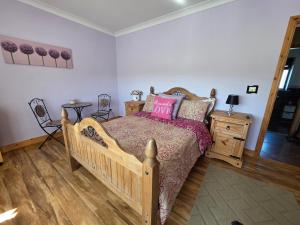 1 dormitorio con cama de madera y almohadas rosas en The Front Room, en Wexford