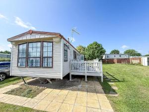 a small white tiny house with a porch in a yard at Great 6 Berth Caravan For Hire At Cherry Tree Holiday Park In Norfolk Ref 70801C in Great Yarmouth