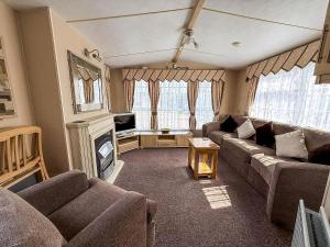 a living room with a couch and a fireplace at Great 6 Berth Caravan For Hire At Cherry Tree Holiday Park In Norfolk Ref 70801C in Great Yarmouth