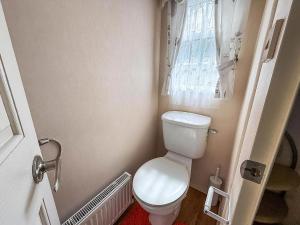 a small bathroom with a toilet and a window at Great 6 Berth Caravan For Hire At Cherry Tree Holiday Park In Norfolk Ref 70801C in Great Yarmouth +12 photos