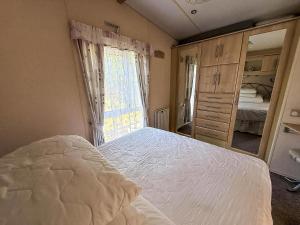 a bedroom with a bed and a large window at Great 6 Berth Caravan For Hire At Cherry Tree Holiday Park In Norfolk Ref 70801C in Great Yarmouth +15 photos