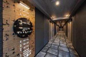 un corridoio con un muro con cartelli di vino di いやし処ほてる寛楽 久留米駅前 a Kurume