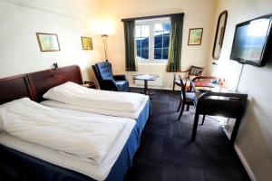 a hotel room with a bed and a table and chairs at Moi Hotel in Moi