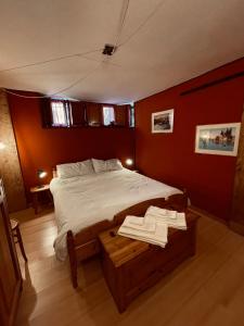 Un dormitorio con una cama y una mesa con toallas. en Cà Nòno - Vista Mozzafiato sulle montagne, en Schilpario