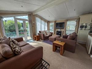 グレート・ヤーマスにあるBeautiful 6 Berth Lodge At Cherry Tree Holiday Park Ref 70002Tgのソファとテレビ付きの広いリビングルーム