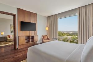 a hotel room with a bed and a television at Courtyard by Marriott Kochi Airport in Nedumbassery