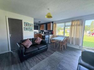 a living room with a couch and a table at Lovely 6 Berth Chalet In Hemsby Nearby Great Yarmouth Ref 73106F in Hemsby