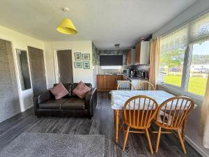 a living room with a table and chairs and a couch at Lovely 6 Berth Chalet In Hemsby Nearby Great Yarmouth Ref 73106F in Hemsby +10 photos