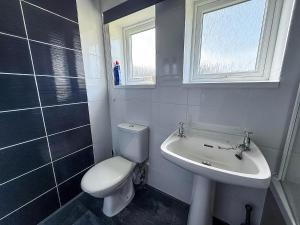 a bathroom with a toilet and a sink at Lovely 6 Berth Chalet In Hemsby Nearby Great Yarmouth Ref 73106F in Hemsby