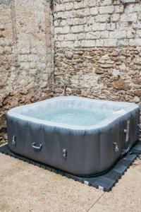 a large bath tub sitting next to a brick wall at The Champenoise Jacuzzi - Vineyard in Verzenay