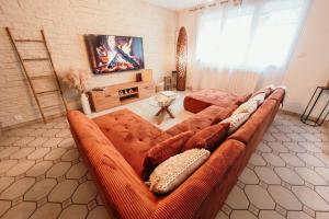 a living room with a large brown couch in a room at The Champenoise Jacuzzi - Vineyard in Verzenay