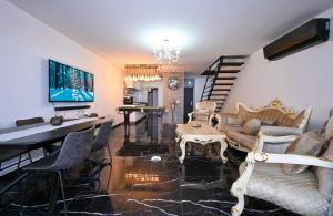 Una sala de estar con un sofá, una mesa y sillas. en נופש תות - דירת אירוח בלב טבריה עם ג'קוזי ספא, en Tiberíades