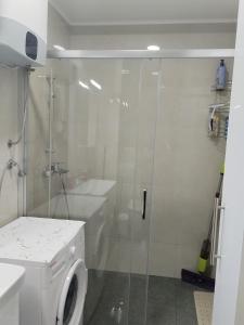 a bathroom with a shower and a washing machine at Sunčano Jutro in Trebinje