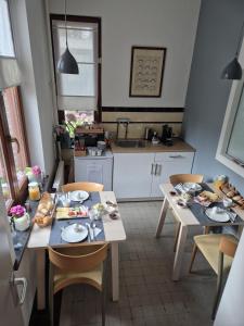 a kitchen with a table and chairs with food on it at B&B De Limburgse Bergen in Berg en Terblijt