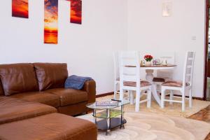 a living room with a couch and a table at KAREN Comfort 3BR Holiday Home Nandi Rd off Miotoni in Nairobi